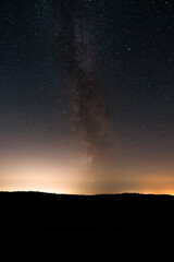 Obraz na płótnie Canvas Milky Way above forest silhouette in clear dark night sky