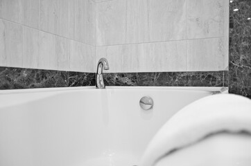 Detailed view into bath tub in marble bathroom of suite category stateroom or cabin onboard luxury...