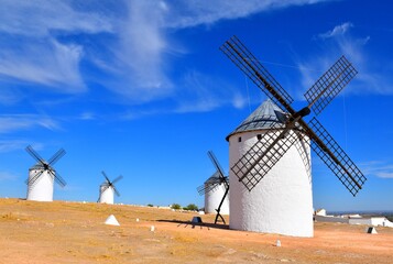 Four windmills in sunny day and dark blue sky. Campo de Criptana.