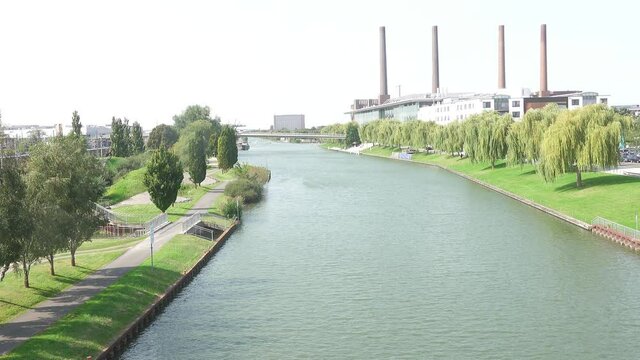 View of the Mittellandkanal in Wolfsburg, Germany, with the chimneys of the factory and the Autostadt