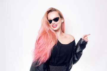 A girl with pink hair in glasses and black clothes shows an empty space for text or a product. Black Friday. Woman smiling