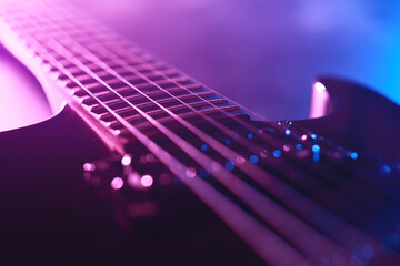 Electric guitar fragment lit with neon light