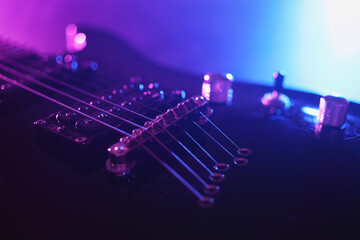 Electric guitar fragment lit with neon light