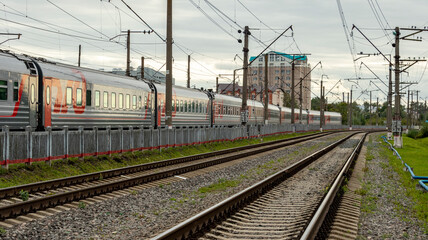 Fototapeta na wymiar a long train of cars on the railway tracks