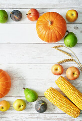 Autumn harvest pumpkin background. Autumn harvest vegetables and fruits. Pumpkins, apples, pears, corn on table. Thanksgiving table.Halloween or seasonal autumnal. Greeting card. Fall kitchen.