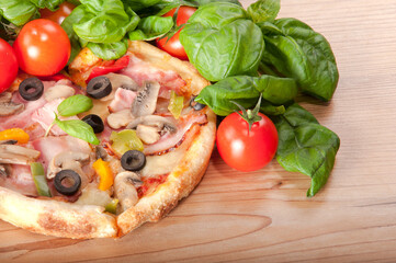 Fototapeta na wymiar Closeup of pizza with tomatoes, cheese and basil on wooden background