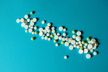 A lot of pills scattered on a blue background. 