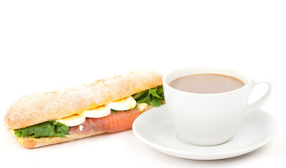 Real sandwich with smoked salmon, eggs and green and cup of a coffee on a white background