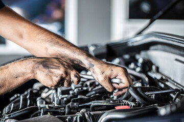 Auto mechanic working and repair on car engine in mechanics garage. Car service.