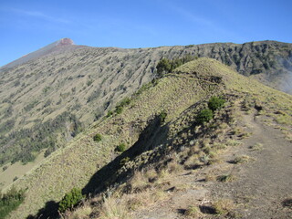Mount Rinjani, the second highest volcano mountain in Indonesia, located in Lombok Island. A mountain with a beautiful crater lake called Segara Anak during a sunny day with blue sky.