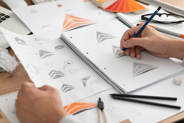 Graphic designer drawing sketches logo design.