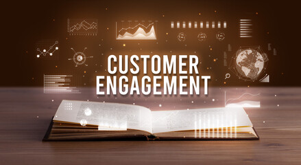 CUSTOMER ENGAGEMENT inscription coming out from an open book, creative business concept