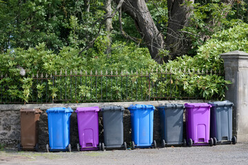 Wheelie bin colour blue, purple and black for refuge collection outside house in a row
