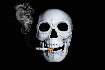 Human skull with smoking cigarette in his mouth on black background. Symbol of dangers of smoking.