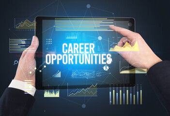 Close-up of hands holding tablet with CAREER OPPORTUNITIES inscription, modern business concept