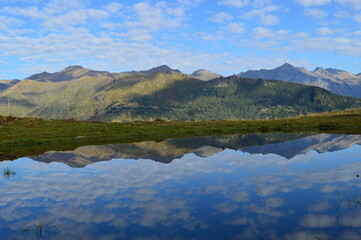 Fototapeta premium Reflections of the mountains around Lake Como in Lombardy, Northern Italy