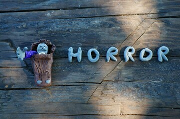 The figure of the zombie from clay peeking out of the coffin.