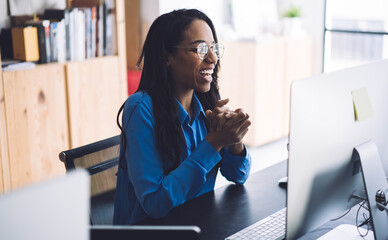 Joyful African American businesswoman using computer at office