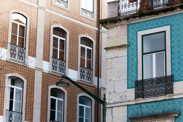 Angle perspective of brown and blue tile buildings in Lisbon. Traditional facades with street light in the middle in Portugal residential area