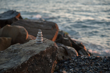 Zen stone pyramid on the seashore in the setting sun