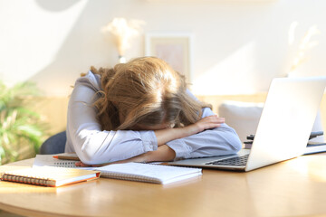 Tired overworked woman resting while she was working writing notes.
