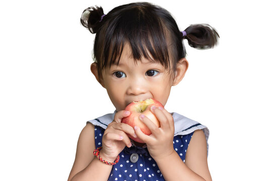 Portrait​ image​ of​ 1-2​ yeas​ old​ of​ baby.​ Happy​ Asian child girl eating and biting an red apple. On white background isolated. Enjoy eating moment. Healthy food and kid concept.