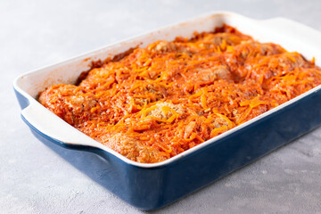 Baked meatballs with cabbage and rice in a baking dish