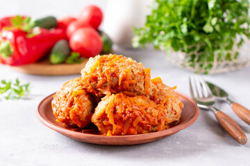 Lazy cabbage rolls with vegetables on concrete background.