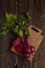 Fresh organic beets. rustic wooden background. Beets with green tops. View from above. Vertical image