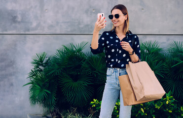Content young woman taking selfie on street