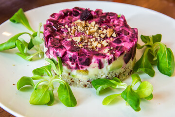 Russian vegetable salad with beetroot, quinoa, walnut and basil leaves.