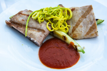 Plate of two pieces of pork, zucchini spaghetti and tomato sauce