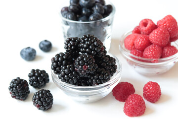 blueberries, raspberries and blackberries in bowls