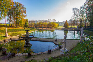 Fototapeta na wymiar Idyllic landscape in Domaine national de Saint-Cloud - awe park and pond with statues at autumn . Golden and red colors of autumn in Paris!