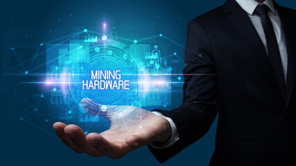 Man hand holding MINING HARDWARE inscription, technology concept