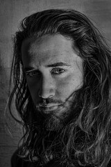 Retrato hombre pelo largo con barba, mirada penetrante, blanco y negro. Fotografía del alma.