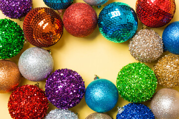 Festive composition of decorative baubles on colorful background. Top view of Christmas toys with copy space