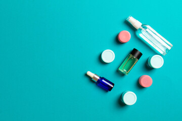 Cosmetics SPA branding mock-up, top view with copy space. set of tubes and jars of cream flat lay on colored background