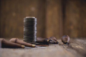 Leather craft tools on old wood table. Leather craft workshop.