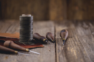 Leather craft tools on old wood table. Leather craft workshop.