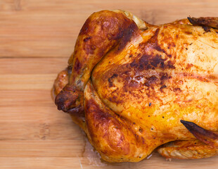 Whole roasted chicken on wooden board