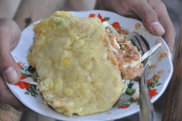 a typical food made of spinach and peanut sauce with fried trivial as a side dish