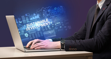 Businessman working on laptop with SUSTAINABLE DEVELOPMENT inscription, cyber technology concept