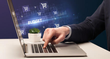 Fototapeta na wymiar Businessman working on laptop with BUDGET inscription, online shopping concept
