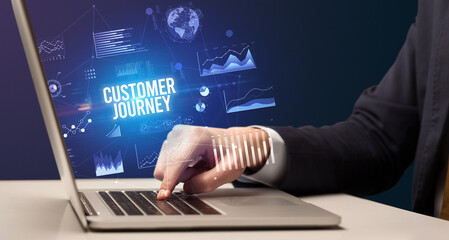 Businessman working on laptop with CUSTOMER JOURNEY inscription, new business concept