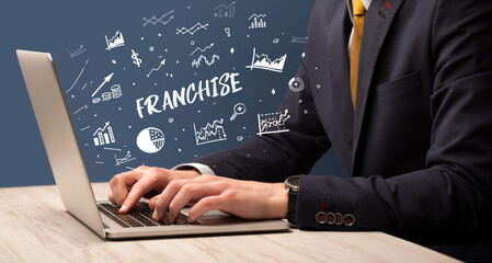 Businessman working on laptop with FRANCHISE inscription, modern business concept