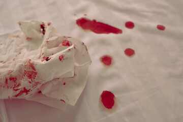 blood stains in bed and a bloody napkin