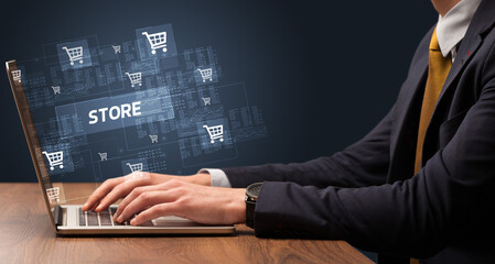 Businessman working on laptop with STORE inscription, online shopping concept