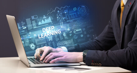 Businessman working on laptop with DEEP LEARNING inscription, cyber technology concept