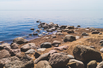 Path to the sea with stones on the sandy shore. summer landscape